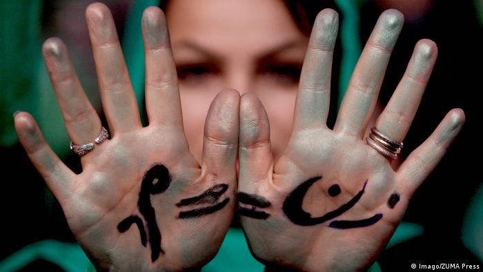 An Iranian women holds up her hands painted with writing in support of a female candidate