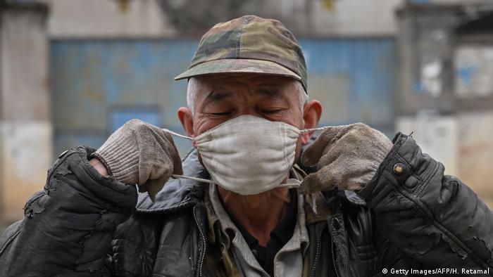 Житель Уханя в медицинской маске из-за вспышки коронавируса