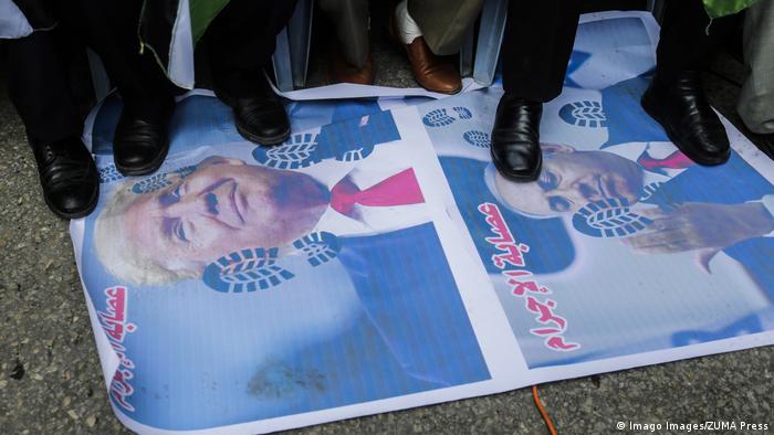 People in the Gaza Strip stepping on a poster of Trump and Netanyahu