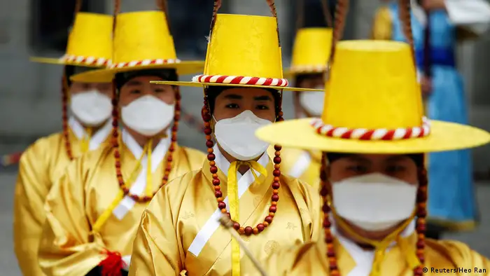 BdTD Südkorea Arbeiterinnen in traditioneller Tracht tragen Schutzmasken