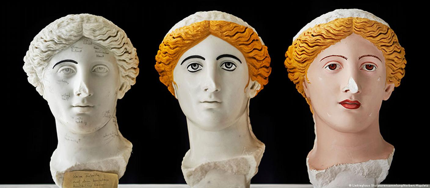 Three statue heads painted in different colors.