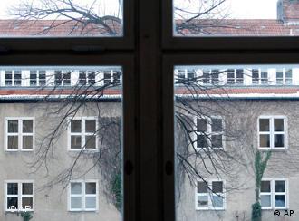 A view of a Catholic college from behind a window with a cross-like frame