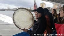 Rana Suliman, 19, plays a traditional Yazidi drum during a boat trip in London, on Feb 3, 2020. Rana is a member of a Yazidi choir in northern Iraq which is providing therapy for survivors of Islamic State atrocities. Handbout by AMAR/Robert Cole