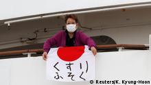A woman holds a Japanese flag that reads shortage of medicine on the cruise ship Diamond Princess, where 10 more people were tested positive for coronavirus on Thursday, to the port as it is anchored at Daikoku Pier Cruise Terminal in Yokohama, south of Tokyo, Japan February 7, 2020. REUTERS/Kim Kyung-Hoon
