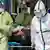 Pasien corona di Wuhan dibawa ke rumah sakit oleh petugas kesehatan dengan pakaian pelindung