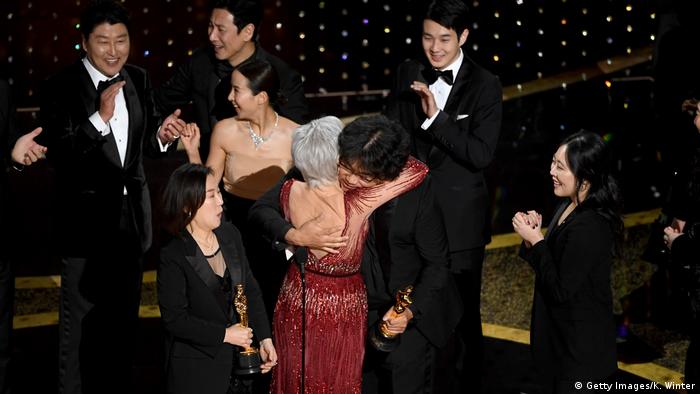 The team behind 'Parasite' hugs one another onstate at the Oscars awards ceremony in L.A.(Getty Images/K. Winter)