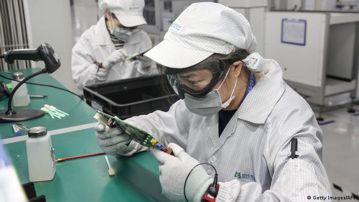 Chinese workers in an electronics factory wearing face masks.