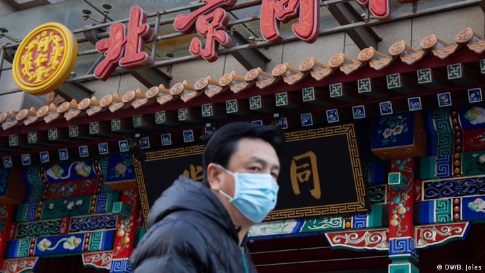 A man walks in front of a store selling medicine in Beijing