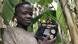 Boy smiles as he holds a radio set in a banana plantation Boy smiles as he holds a radio set in a banana plantation