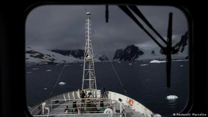 The front deck of a ship and a snowy landscape in the distance - as seen through a window. 