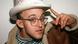 Keith Haring posiert mit Hut und greift sich an die Hutkrempe Keith Haring posiert mit Hut und greift sich an die Hutkrempe