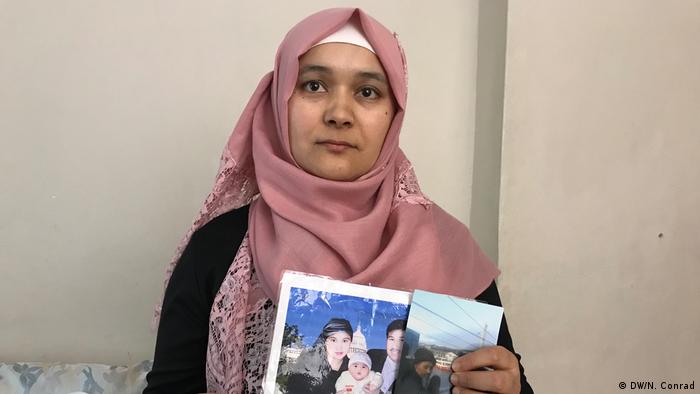 A Uighur in Istanbul, Rozinisa Memet Tohti, holds pictures of family 