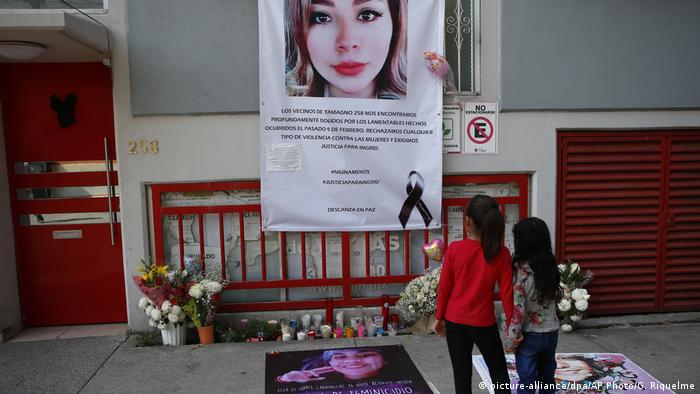 Girls stand in front of a makeshift alter in memory of Ingrid Escamilla who was allegedly murdered by her partner in February
