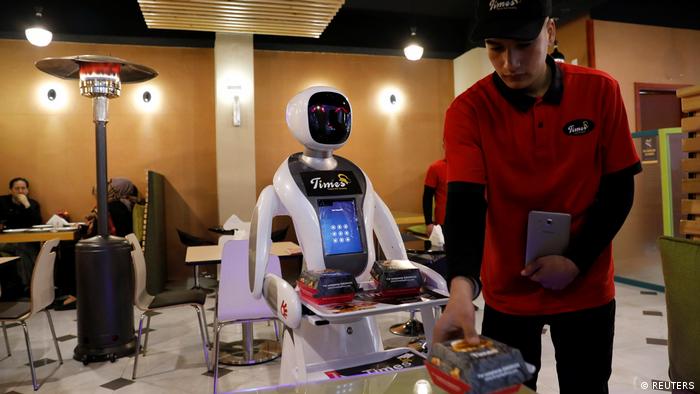 A waitress robot (Timea) delivers food to a table at the Times Fast Food restaurant in Kabul