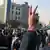 A demonstrator in Tehran holds up his hand to form a peace sign