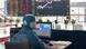 A person sits at a computer in a hazard suit, in Shnaghai, China A person sits at a computer in a hazard suit, in Shnaghai, China
