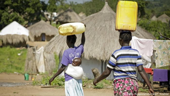 Uganda Junge Frauen transportieren Kanister mit Wasser auf ihrem Kopf