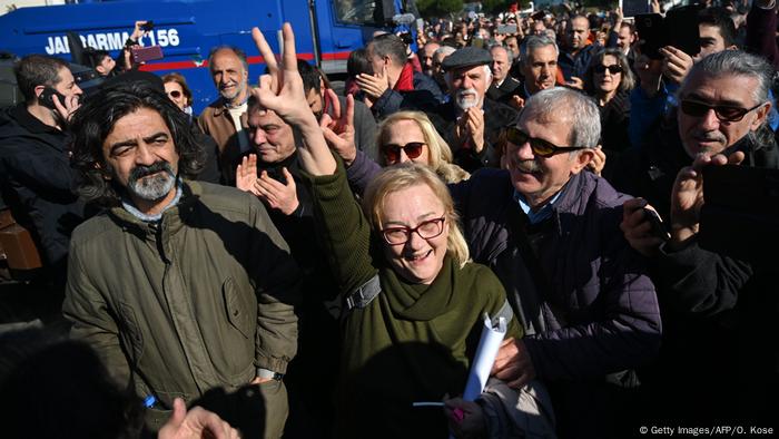 A mass of people smiling, clapping, and a woman showing a victory sign: Supporters celebrate in Istanbul after Osman Kavala's acquittal on February 18, 2020.