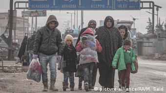 Uma família é vista a caminho de zonas mais seguras com seus pertences