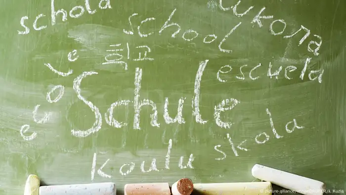 Das Wort Schule in mehreren Sprachen auf einer Tafel