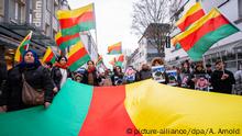 22.02.2020, Hessen, Hanau: Der Demozug zieht mit kurdischen Flaggen durch die Innenstadt. Ein Bündnis gegen Hetze und Menschenverachtung hat zu einer Demonstration aufgerufen. Die Teilnehmer wollen vom Freiheitsplatz in der Innenstadt zu den beiden Tatorten gehen. Bei einem mutmaßlich rassistischen Anschlag hatte ein 43-jähriger Deutscher im hessischen Hanau mehrere Menschen und sich selbst erschossen. Foto: Andreas Arnold/dpa +++ dpa-Bildfunk +++ | Verwendung weltweit