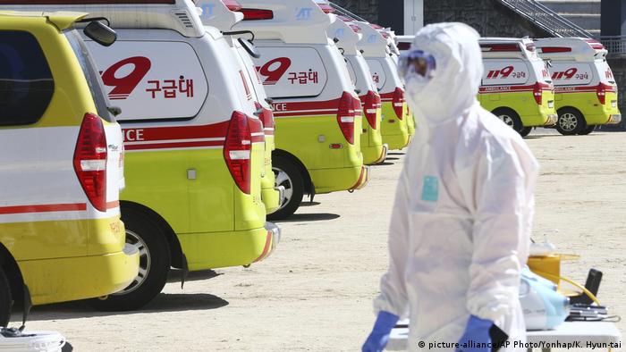 A South Korean paramedic stands behind ambulances