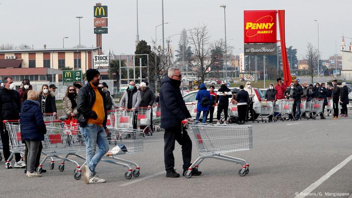 Personas hacen cola con carros de supermercado vacíos. (Reuters/G. Mangiapane)