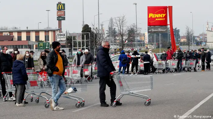 Gut 30 Personen warten mit leeren Einkaufswagen in einer Reihe (Reuters/G. Mangiapane)