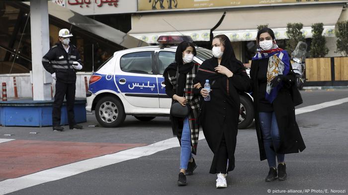 نساء يضعن كمامات واقية خلال سيرهن في قلب طهران