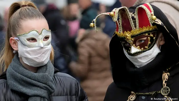 Zwei Personen mit dekorativen Gesichtsmasken sowie Atemschutzmasken (Reuters/M. Silvestri)