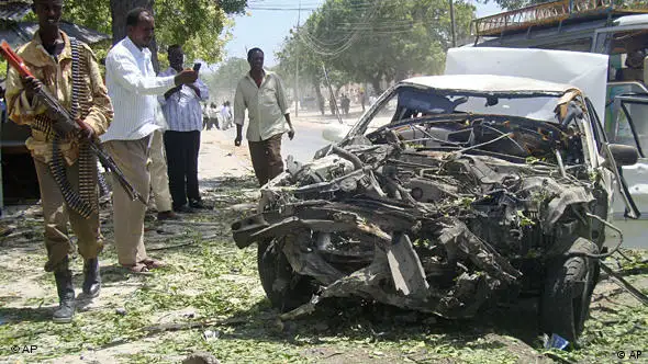 Ein Regierungssoldat neben dem zerstörten Wagen des Selbstmordattetntäters in Mogadischu (Foto: AP)