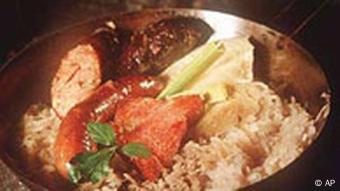 Deutsches Essen: Sauerkraut mit Würstchen, Knödeln und Fleisch