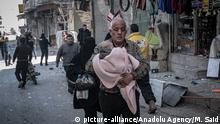 25.02.2020 *** IDLIB, SYRIA - FEBRUARY 25: A man carries a baby amid damaged buildings and marketplace to a safer zone, as Assad regime carried out an airstrikes over Idlib, Syria on February 25, 2020. Muhammed Said / Anadolu Agency | Keine Weitergabe an Wiederverkäufer.