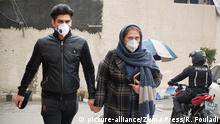 26.02.2020, Iran, Teheran: Ein junges Paar trägt Mundschutzmasken, als es durch eine Straße im Norden der Stadt geht. Foto: Rouzbeh Fouladi/ZUMA Wire/dpa +++ dpa-Bildfunk +++ |