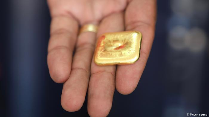 Un persona sujeta un objeto de oro. 