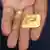 A close-up of a hand holding a nugget of gold