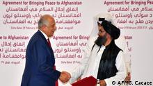 29.02.2020 *** (L to R) US Special Representative for Afghanistan Reconciliation Zalmay Khalilzad and Taliban co-founder Mullah Abdul Ghani Baradar shake hands after signing a peace agreement during a ceremony in the Qatari capital Doha on February 29, 2020 - The United States signed a landmark deal with the Taliban, laying out a timetable for a full troop withdrawal from Afghanistan within 14 months as it seeks an exit from its longest-ever war. (Photo by Giuseppe CACACE / AFP)