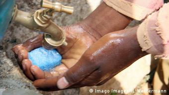 Pessoa a lavar as mãos com água e sabão 