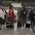 Foto de personas con maletas y mascarillas en el Aeropuerto de México