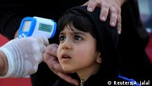 A member of the medical team checks the temperature of a child, following the coronavirus outbreak, at a checkpoint on the outskirts of Duhok, Iraq March 2, 2020. REUTERS/Ari Jalal TPX IMAGES OF THE DAY
