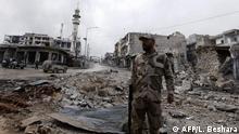 A picture taken during a guided tour organised by the Syrian ministry of information, shows a pro-regime fighter standing in the midst of rubble and buildings damaged by deadly regime and Russian air strikes, in the town of Maaret al-Numan, in the northwestern Idlib province, on January 30, 2020. - Syrian government forces recaptured the strategic northwestern highway town of Maaret al-Numan from jihadist and allied rebels on January 28, in the latest blow to the country's last major opposition bastion. (Photo by LOUAI BESHARA / AFP)