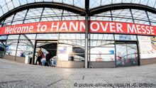 ARCHIV - 03.04.2019, Niedersachsen, Hannover: Besucher verlassen durch den südlichen Eingang das Messegelände, während der Schriftzug «Welcome to Hannover Messe» über den Eingangstüren hängt (Aufnahme mit Fisheye-Objektiv). Wegen der anhaltenden Ausbreitung des neuartigen Coronavirus verschieben die Veranstalter der Hannover Messe die weltgrößte Industrieschau. Foto: Hauke-Christian Dittrich/dpa +++ dpa-Bildfunk +++ | Verwendung weltweit