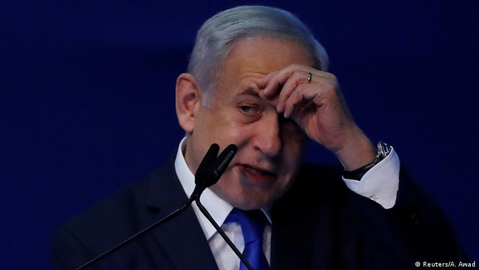 Benjamin Netanjahu wipes his forehead with his hand