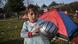 A young girl holds a ball in front of a tent at a migrants' makeshift camp A young girl holds a ball in front of a tent at a migrants' makeshift camp