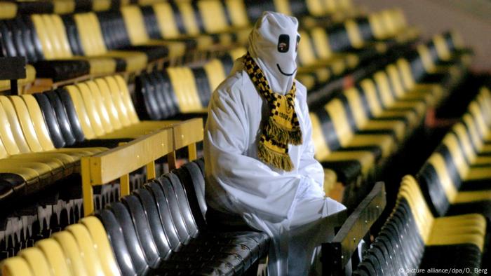 Un fanático disfrazado de fantasma en un estadio. 