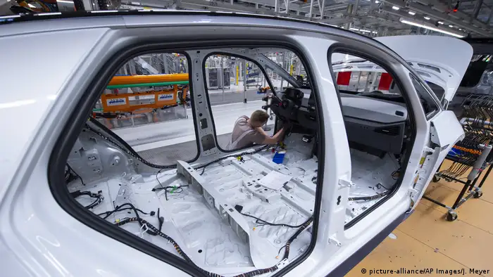 A worker completes an electric car body at the assembly line at the plant of the German manufacturer Volkswagen AG (VW) in Zwickau, eastern Germany