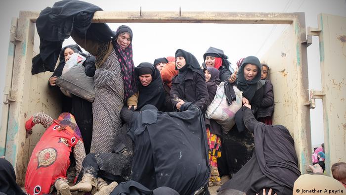 Local women in western Mosul climb onto a truck to flee the combat zone as Iraqi forces battle the Islamic State militants in March 2017. (Jonathan Alpeyrie)