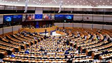 Members of the EU Parliament arrive and sit in an empty hemicycle at the beginning of the plenary session which is reduced to a single day due to the spread of the COVID-19 illness, in Brussels, on March 10, 2020. - All European Union States are hit by the novel coronavirus. (Photo by Kenzo TRIBOUILLARD / AFP)