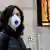 Mulher usa máscara em estação de trem em Milao