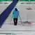 Ein Olympiahelfer auf der Curling-Bahn. Foto: AP